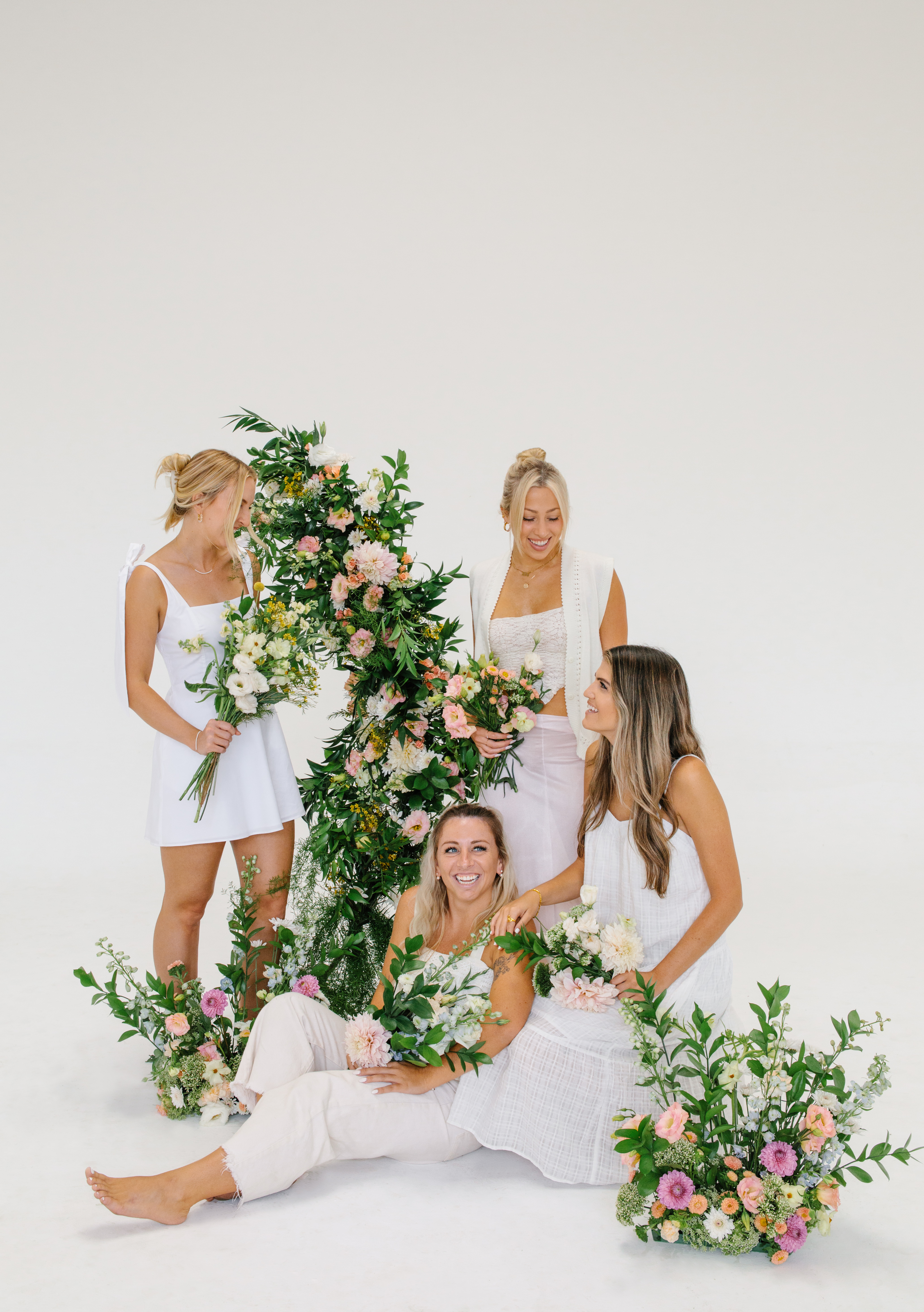 Florist team smiling next to flower arrangements